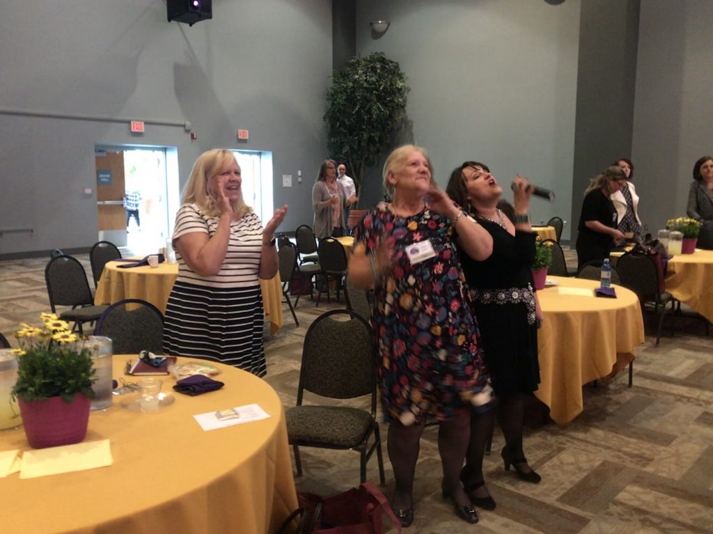 From left, Grundy clubwomen Sandy Stiltner and Diane Lynch sing along with special guest speaker Wynonah Dove Bush during the Women in Entrepreneurship Conference at the Higher Education Center in Abingdon, VA.